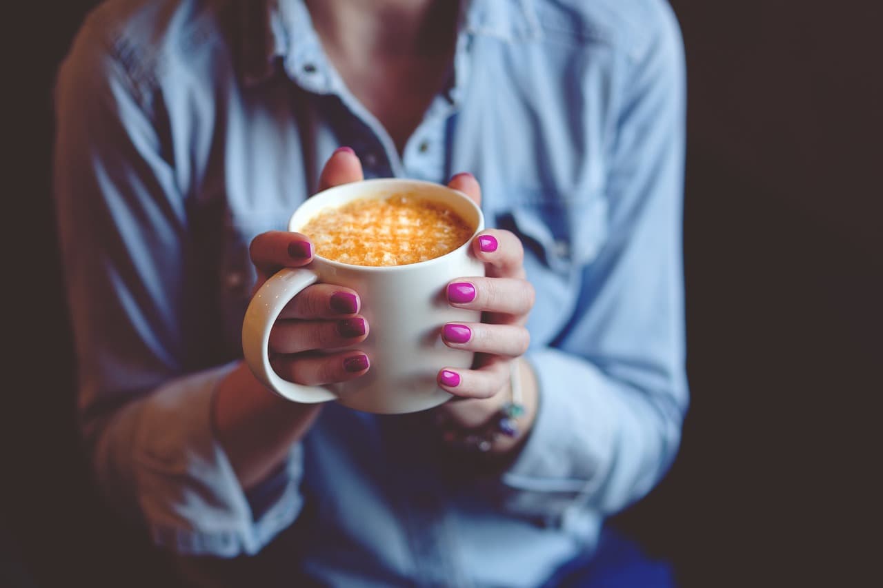 a person holding a coffee drink